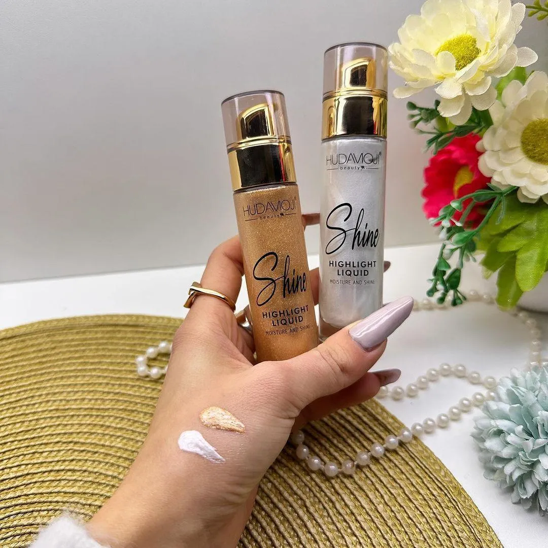 HUDAMOJI Shine Highlight Liquid, a lightweight and blendable illuminator designed for a smooth, radiant finish. Its silky liquid formula melts beautifully into the skin, delivering a luminous shimmer that lasts all day. Perfect for highlighting the face and body, 